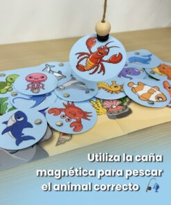 Caña de pescar magnética atrapando una pieza redonda de una langosta sobre un tablero ilustrado con animales marinos y el texto utiliza la caña magnética para pescar el animal correcto.