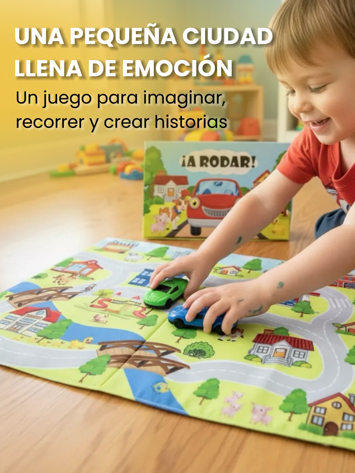 Niño pequeño jugando en el suelo sonriente mientras desplaza dos autitos de plástico sobre un tapiz ilustrado con calles y casas.