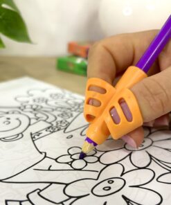 Niño pintando una lámina de dibujo utilizando un lápiz de color morado con soporte ergonómico de silicona.