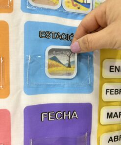 Mano deslizando la ficha ilustrada de Invierno en la sección transparente de estación del calendario interactivo.
