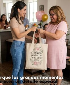 Fotografía de estilo de vida que muestra una bolsa de tela estilo totebag color crema como segunda imagen de producto. Una joven le entrega la bolsa personalizada a su madre en una reunión familiar. El producto destaca en primer plano con un diseño subimado de flores y una frase de agradecimiento, ilustrando la calidad del acabado a pedido.