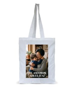 Bolsa de tela estilo totebag de color blanco personalizada con una fotografía impresa en alta calidad de un niño abrazando a su abuela y el texto inferior Te amamos abuelita.