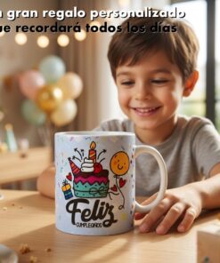 Un niño sonrie frente a una taza personalizada con diseño de torta de cumpleaños y globos sobre una mesa de madera.