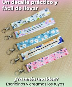 Cinco modelos de llaveros de cinta sublimados con variados estampados coloridos sobre superficie de madera.